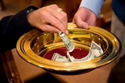People filling the offering plate with money